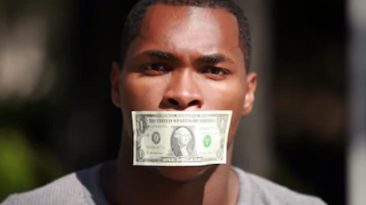 Man with money over mouth