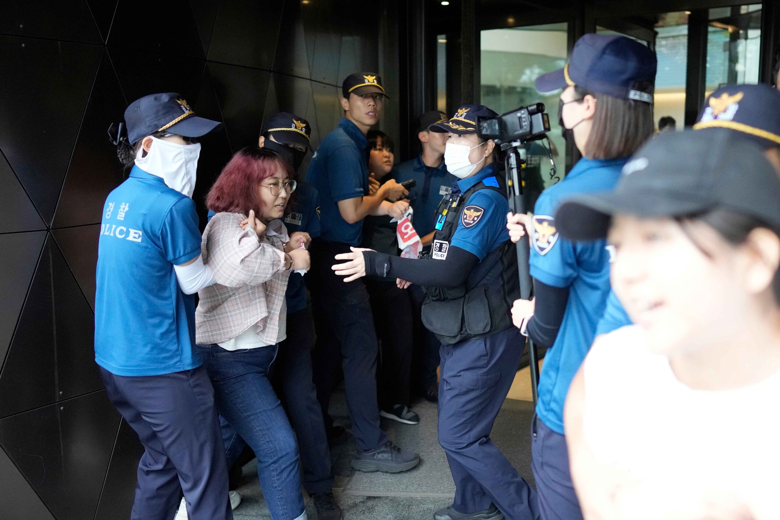 South Korean students are detained by police officers as they attempt to enter to Japanese Embassy to protest denouncing to release treated radioactive water into the sea from the damaged Fukushima nuclear power plant, at a building which houses Japanese Embassy, in Seoul, South Korea, Thursday, Aug. 24, 2023. The operator of the tsunami-wrecked Fukushima Daiichi nuclear power plant says it has begun releasing its first batch of treated radioactive water into the Pacific Ocean — a controversial step, but a milestone for Japan's battle with the growing radioactive water stockpile. (AP Photo/Lee Jin-man)