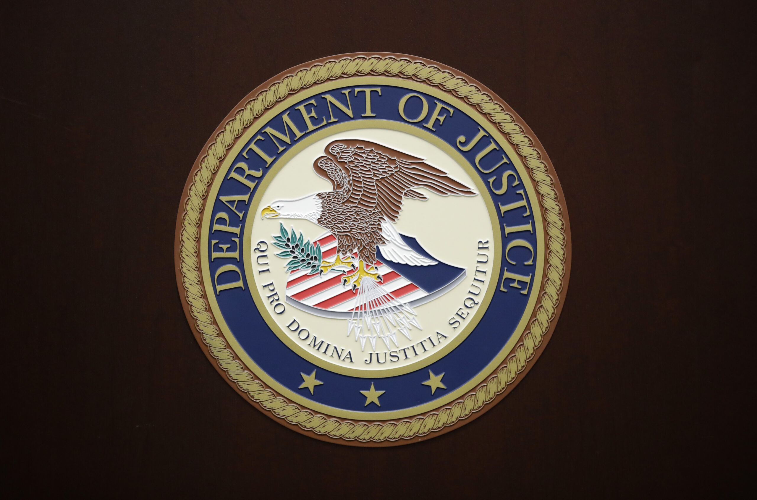 FILE - The U.S. Department of Justice logo is seen on a podium following a news conference in the office of the U.S. Attorney for the District of Maryland in Baltimore, March 1, 2017. On Thursday, Aug. 24, 2023, the U.S. Department of Justice filed suit against SpaceX, the rocket company founded and run by Elon Musk, for alleged hiring discrimination against refugees and people seeking or already granted asylum. (AP Photo/Patrick Semansky, File) American law enforcement announced that an international task force successfully took down “Qakbot,” a botnet malware platform controlled by foreign hackers.