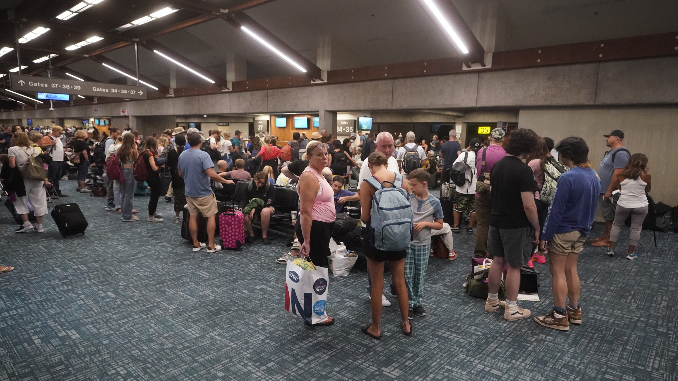 Dozens Dead After Wildfires Destroy Historic Hawaiian Town of Lahaina. People gather while waiting for flights at the Kahului Airport Wednesday, Aug. 9, 2023, in Kahului, Hawaii. Several thousand Hawaii residents raced to escape homes on Maui as the Lahaina fire swept across the island, killing multiple people and burning parts of a centuries-old town. (AP Photo/Rick Bowmer)
