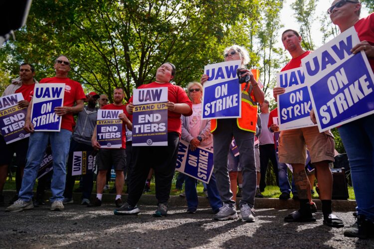 The United Auto Workers union has sent another 5,600 members to General Motors and Chrysler-parent Stellantis, expanding its work stoppage strike efforts.