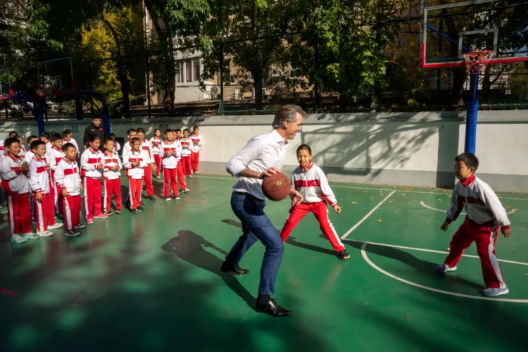 California Governor Gavin Newsom accidentally knocked over a small child while playing basketball during a diplomatic visit to China to discuss climate change. (Gov. Gavin Newsoms office)