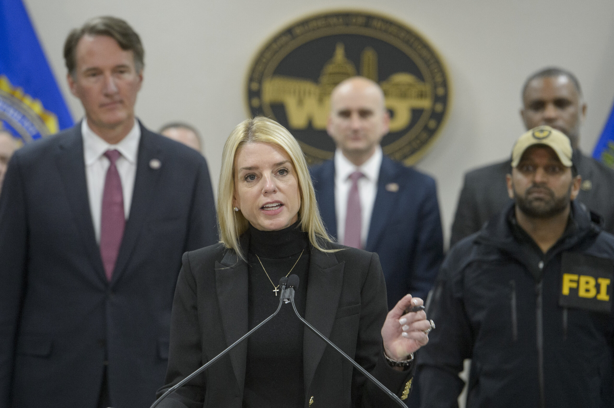 Attorney General Pam Bondi, center, joined by Virginia Gov. Glenn Youngkin, left, and FBI Director Kash Patel, right,speaks about an MS-13 gang leader who was arrested in an operation by the Virginia Homeland Security Task Force, during a news conference at the Manassas FBI Field Office, Thursday, March 27, 2025, in Manassas, Va. (AP Photo/Rod Lamkey, Jr.)